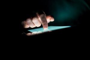 homem usando um tablet no escuro