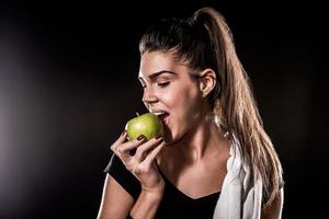 poder fitness comendo maçã em fundo preto
