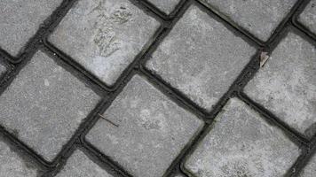 textura de pedras de pavimentação. enfrentando azulejos cinza como fundo vintage foto