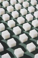 açúcar refinado em background.cubes verde de açúcar doce e branco em forma geométrica. sombras duras. foto
