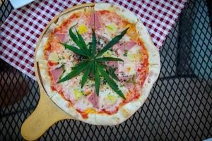 pizza uma mistura de folhas de cannabis, desenvolvida para os amantes da saúde em uma forma nova, licenciada e legal. segurança garantida, ajudar a aliviar a ansiedade, reduzir a tristeza. conceito de cannabis para a saúde. foto