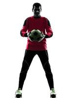 homem de goleiro de jogador de futebol caucasiano segurando a silhueta de bola foto