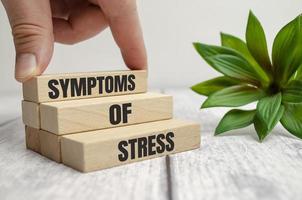 sintomas do símbolo de estresse. palavras de conceito sintomas de estresse em blocos de madeira. foto
