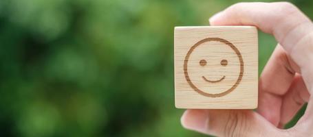 sorria o símbolo de rosto de emoção em blocos de madeira. classificação de serviço, classificação, revisão do cliente, satisfação, avaliação e conceito de feedback foto