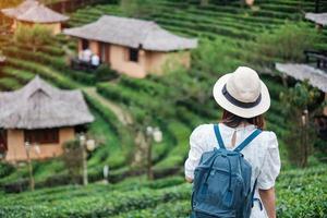 mulher de turista feliz no vestido branco desfrutar de belo chá garden.traveler visitando na vila tailandesa de ban rak, mae hong son, tailândia. conceito de viagens, férias e férias foto