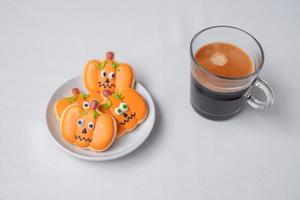 café expresso quente ou xícara de chocolate com biscoitos engraçados de halloween. feliz dia das bruxas, truque ou ameaça, olá outubro, outono outono, tradicional, festa e conceito de feriado foto