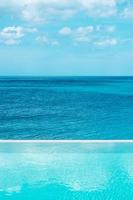 piscina infinita no hotel de luxo contra o mar, resort tropical. relaxante, verão, viagens, férias, férias e conceito de fim de semana foto
