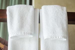closeup toalha limpa pendurada no guarda-roupa de madeira no hotel de luxo. relaxar e viajar conceito