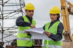 engenheiros homem e mulher trabalhando no canteiro de obras. gerente de construção e mulher arquiteta reunião e discussão sobre o projeto no canteiro de obras. foto