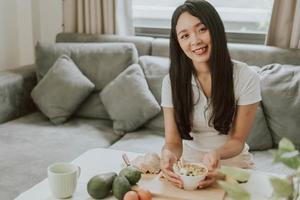 jovem mulher cozinhando comida saudável em casa. conceito de saudável e bem-estar. foto