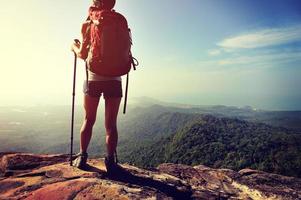 alpinista de mulher apreciar a vista no penhasco de pico de montanha foto