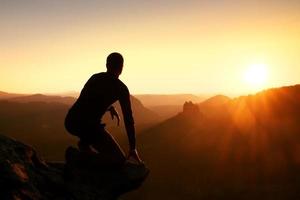 alpinista leve relaxar e apreciar o pôr do sol no horizonte. efeito vívido. foto