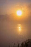 nascer do sol sobre o lago com o reflexo na água.