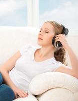 mulher em fones de ouvido gosta de música em casa foto