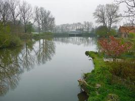 bela cena água reflete à beira do lago no parque verde de brugge bélgica foto