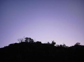 lindo céu ilumina cor pastel com sombra escura de paisagem de montanha de silhueta foto