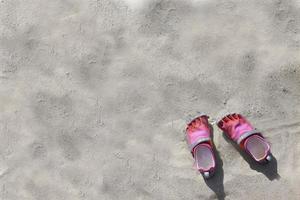 calçado de esporte aquático cinza rosa colorido na praia de areia para segundo plano foto