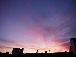 céu de cor pastel, clima romântico no amanhecer da noite com primeiro plano de edifícios de silhueta foto