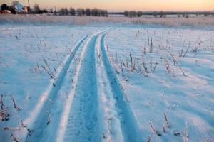 paisagem de inverno, marcas de pneus na neve, estrada de neve foto