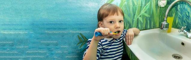 close-up de menino escovando os dentes na cadeira de dentistas foto
