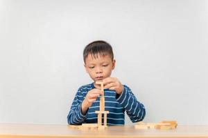 menino brincando com blocos de madeira em casa foto