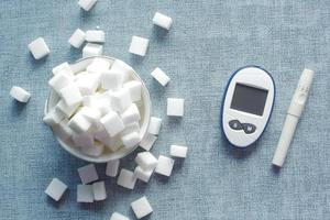 ferramentas de medição diabética e cubo de açúcar branco na mesa foto