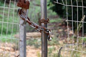 um cadeado de ferro está pendurado em um portão fechado foto