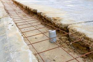 trabalhador mede o nível de malha de arame de laje de concreto que é usado para reforço estrutural da estrada foto
