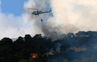 um helicóptero da ONU apaga um incêndio em uma floresta na fronteira israel-líbano. foto