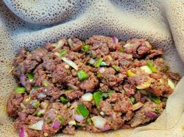 iguaria etíope de carne crua chamada kitfo com pão e pimentão foto