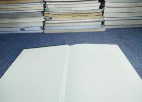 livro branco vazio com uma pilha de livros dando ideias gravação de dados de preparação para exames foto