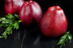 maçãs vermelhas em um fundo escuro de madeira. foco seletivo. colheita. comida saudável. foto