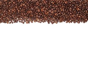 grãos de café torrados. vista superior textura de grãos de café marrom isolada em branco foto