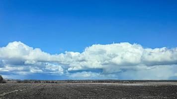 tempo de semeadura na ucrânia durante a guerra. preparando campos para semear grãos. céu azul, terra arada. terror. foto