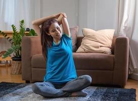 aliviar o estresse, relaxar os músculos, praticar respiração, exercício, meditação. mulher praticando ioga e músculos em casa de férias. foto