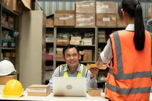 o gerente do armazém deu um prêmio à assistente feminina. que auxiliou no trabalho e planejamento da preparação dos produtos a serem vendidos aos lojistas até que teve muito sucesso foto