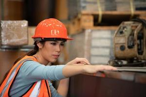 retrato de uma mulher asiática com grandes máquinas usadas em plantas industriais pesadas. foto