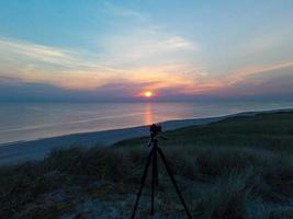 câmera no tripé gravando o pôr do sol foto