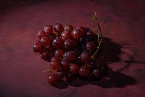uvas vermelhas e maduras em uma mesa rústica foto