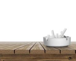 cinzeiro cheio de pontas de cigarro na mesa de madeira no fundo branco foto