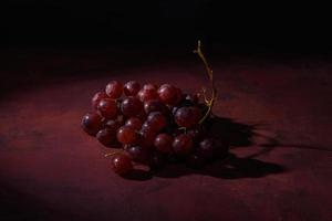 uvas vermelhas e maduras em uma mesa rústica foto