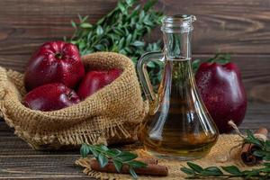 vinagre de maçã e maçãs vermelhas em um fundo escuro de madeira. foco seletivo. produto fermentado. comida saudável. foto
