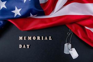 conceito de dia memorial. bandeira americana e placas de identificação militar em fundo preto. lembrar e honrar. foto
