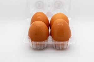 quatro ovos frescos em pacote plástico transparente aberto foto