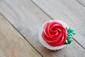 cupcake de rosa vermelha na mesa de madeira foto