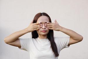 mulher asiática cobrindo os olhos com a mão foto