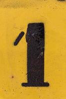 estêncil de número preto pintado em fundo amarelo, número 1, número um foto