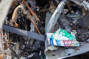 mapa de papel da cidade de kyiv no interior de um carro quebrado. carro abandonado na estrada. o carro queimou completamente. tradução kyiv, rodovias. ucrânia, irpen - 12 de maio de 2022. foto