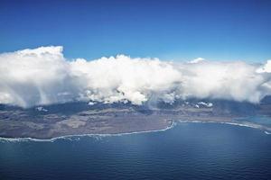 vista aérea idílica de nuvens cobrindo a paisagem e o mar azul contra o céu foto