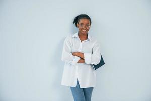 posando para uma câmera. jovem mulher afro-americana é contra o fundo branco foto